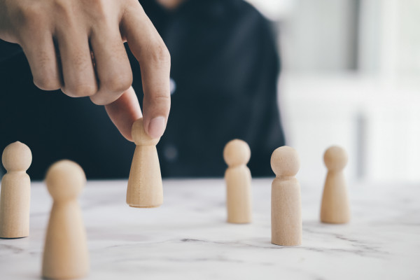 vecteezy_close-up-of-person-placing-wooden-figure_1269712